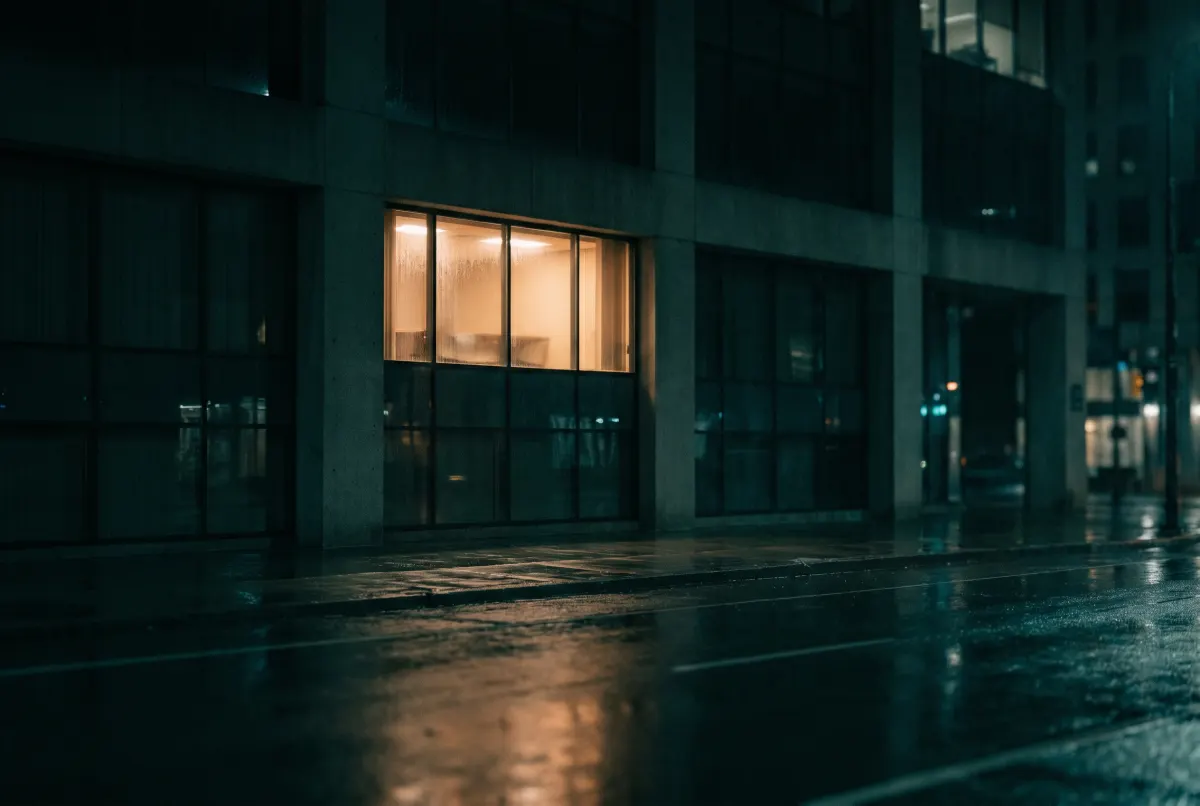 A single lit window in a dark building at night