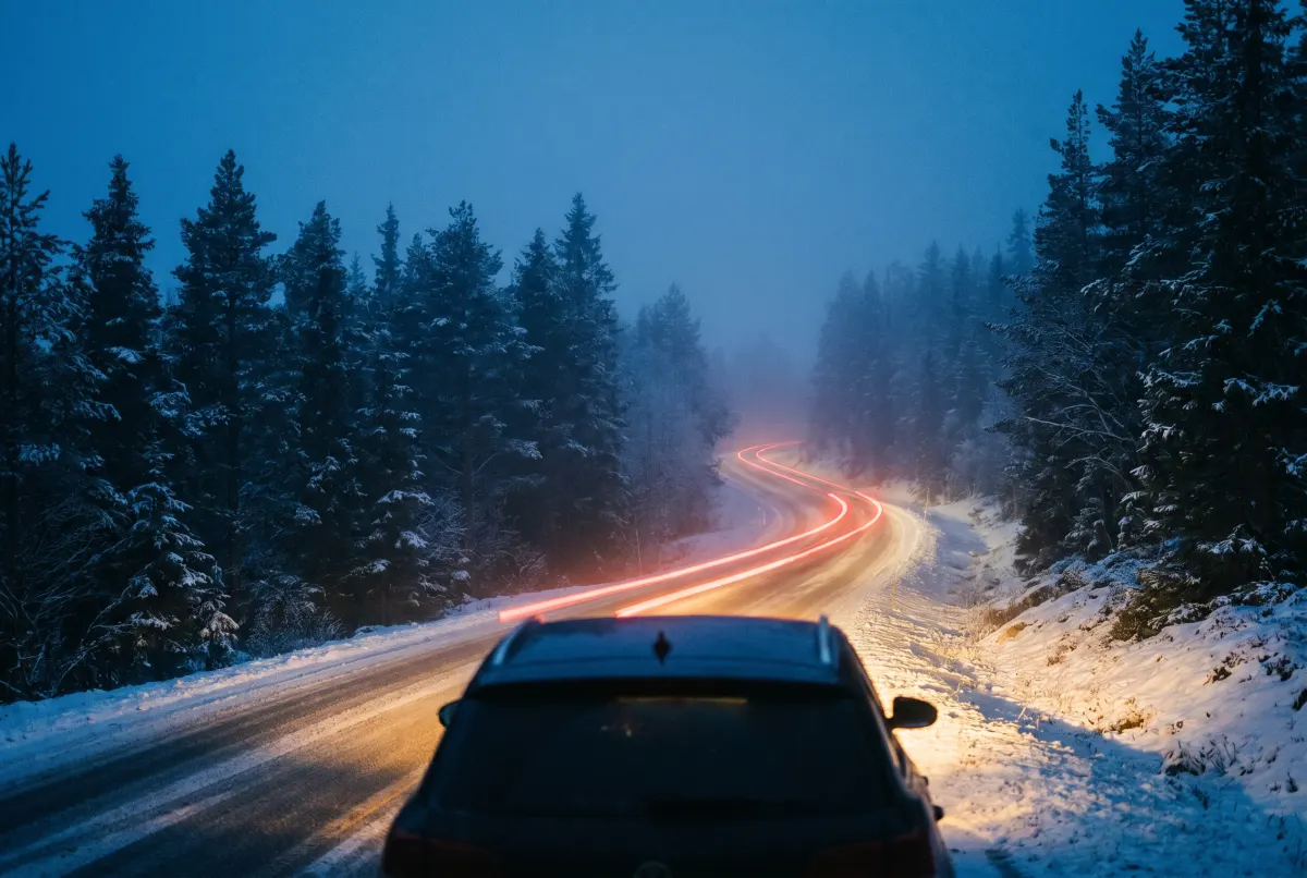 A snow-covered Norwegian mountain road at dusk